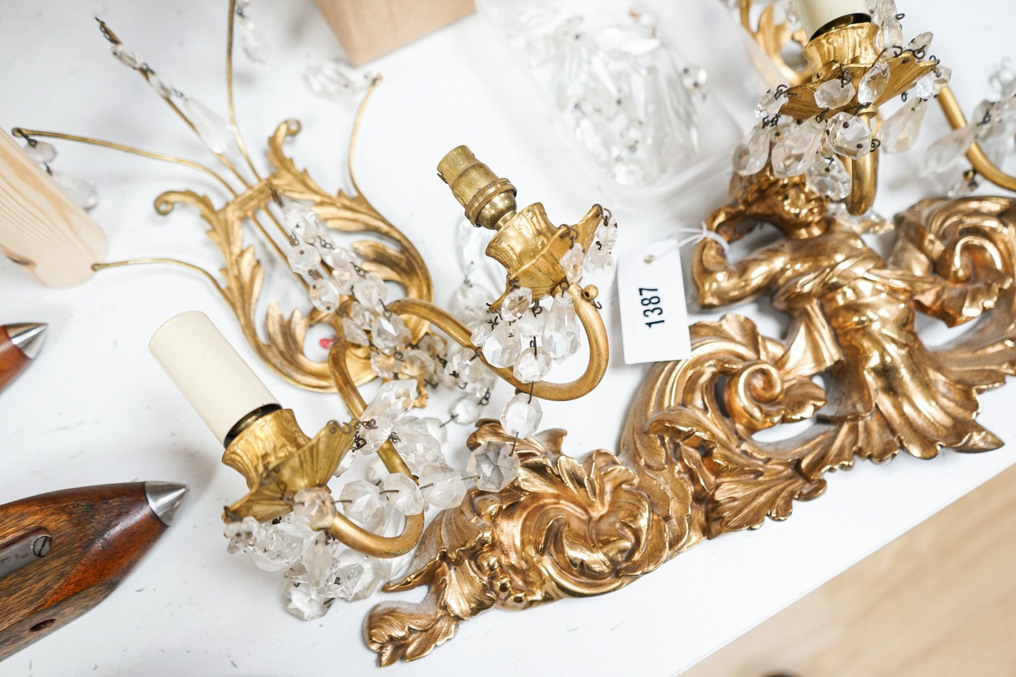 A pair of ormolu and cut glass twin branch wall lights, a bag light and a brass mount